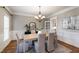 Formal dining room with elegant chandelier, wainscoting, and a neutral color palette at 307 Beacon Falls Ct, Cary, NC 27519