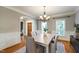 Elegant dining area with hardwood floors, a modern chandelier, and serene natural light at 307 Beacon Falls Ct, Cary, NC 27519