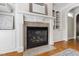 Living room fireplace with white mantel and built-in shelving on either side with tile surround at 307 Beacon Falls Ct, Cary, NC 27519