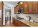 Stylish kitchen featuring granite counters, stainless steel appliances, gas cooktop, and wood cabinets at 307 Beacon Falls Ct, Cary, NC 27519