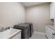 A laundry room featuring a white sink, countertop, and gray washer and dryer at 307 Beacon Falls Ct, Cary, NC 27519