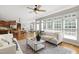Bright living room featuring a ceiling fan, large windows, and an open floor plan at 307 Beacon Falls Ct, Cary, NC 27519