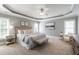 Spacious main bedroom featuring tray ceilings, carpeted floors, and large windows at 307 Beacon Falls Ct, Cary, NC 27519