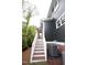 Exterior view of a home with gray siding, white trim, and wooden stairs leading to the entrance at 415 E Lavender Ave, Durham, NC 27704