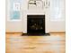 Elegant fireplace with white mantel, black surround, and light hardwood floors at 415 E Lavender Ave, Durham, NC 27704