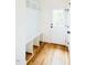 White mudroom with storage bench, overhead shelves, and a glass-paneled exterior door at 415 E Lavender Ave, Durham, NC 27704