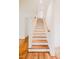 Bright, wooden staircase with white risers and railings creates a classic and welcoming feel at 415 E Lavender Ave, Durham, NC 27704