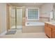 Bright bathroom featuring a bathtub, shower with glass door, and a tile floor at 4219 Peachway Dr, Durham, NC 27705