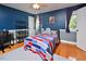 Bedroom with dark blue walls, wood flooring, and natural light from a window at 4219 Peachway Dr, Durham, NC 27705