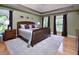 Spacious bedroom with hardwood floors, multiple windows, and a tray ceiling at 4219 Peachway Dr, Durham, NC 27705