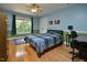 Comfortable bedroom with a ceiling fan, hardwood floors, and a large window view at 4219 Peachway Dr, Durham, NC 27705