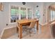 Sunlit breakfast nook features a wood table, four chairs, and views through a series of windows at 4219 Peachway Dr, Durham, NC 27705
