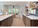 Gourmet kitchen with large island, stainless steel appliances, wooden cabinetry, and views to a screened porch at 4219 Peachway Dr, Durham, NC 27705