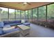 Screened in porch features a large sofa and a center table with views of the lush green yard at 4219 Peachway Dr, Durham, NC 27705