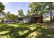 Back exterior view with green, tree-lined backyard and spacious driveway at 438 N Hickory St, Angier, NC 27501