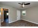 Bedroom with hardwood floors, ceiling fan, ensuite bathroom entrance, and window at 438 N Hickory St, Angier, NC 27501