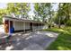 Back exterior view showing a spacious paved driveway and shady yard at 438 N Hickory St, Angier, NC 27501
