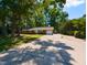 Charming brick ranch-style home with an attached garage, mature trees, and a spacious driveway at 438 N Hickory St, Angier, NC 27501