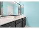 Bright bathroom with a black vanity, white countertop, and turquoise walls at 4649 Pine Trace Dr, Raleigh, NC 27613