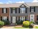 Charming townhome featuring a glass front door, black shutters, and manicured landscaping at 4649 Pine Trace Dr, Raleigh, NC 27613