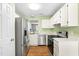 Well-lit kitchen with white cabinets, stainless steel appliances, and an open layout at 4649 Pine Trace Dr, Raleigh, NC 27613
