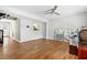 Bright living room featuring hardwood floors, a ceiling fan, and an open view to the kitchen at 4649 Pine Trace Dr, Raleigh, NC 27613