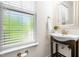 Bright powder room featuring a decorative mirror, elegant vanity, and natural light at 4963 Highcroft Dr, Cary, NC 27519