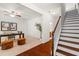 Entryway with wooden staircase flowing into an office space with large desk and neutral carpet at 4963 Highcroft Dr, Cary, NC 27519