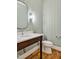 Charming powder room featuring wood vanity, white marble sink, and modern fixtures against a light green wall at 503 Damascus Church Rd, Chapel Hill, NC 27516