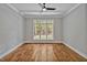 Empty bedroom with hardwood floors, crown molding, and a large window overlooking the backyard at 503 Damascus Church Rd, Chapel Hill, NC 27516
