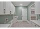 Well-appointed laundry room featuring white cabinets, a sink, and modern appliances at 503 Damascus Church Rd, Chapel Hill, NC 27516