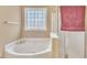 Bathroom featuring soaking tub and glass block window at 513 Woodson Dr, Clayton, NC 27527