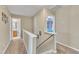 Upstairs hallway featuring neutral colors and railing overlooking staircase at 513 Woodson Dr, Clayton, NC 27527