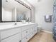 Bright bathroom featuring a double sink vanity with a large mirror and decorative accents at 5505 Crabtree Park Ct, Raleigh, NC 27612