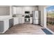 Open kitchen with white cabinets, stainless steel appliances, quartz countertops, and natural light at 5505 Crabtree Park Ct, Raleigh, NC 27612