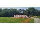Framed home under construction showcasing the initial structure and design in a grassy lot surrounded by trees at 5545 Silk Hope Gum Springs Rd, Siler City, NC 27344