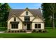 Charming exterior elevation of a craftsman-style home with manicured landscaping and a rocking chair on the front porch at 5545 Silk Hope Gum Springs Rd, Siler City, NC 27344