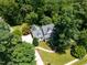 Aerial view showcases the home nestled among mature trees, with lush green surroundings at 5940 Dahlberg Dr, Raleigh, NC 27603