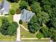 Birds-eye view of a home surrounded by a green lawn and tree coverage, featuring a circular drive at 5940 Dahlberg Dr, Raleigh, NC 27603
