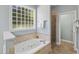 Bathroom featuring soaking tub and separate shower with natural light at 5940 Dahlberg Dr, Raleigh, NC 27603