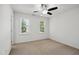 Cozy bedroom with neutral carpet, a ceiling fan, and two windows letting in natural light at 5940 Dahlberg Dr, Raleigh, NC 27603