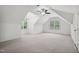Bright bonus room with neutral carpet, ceiling fan, and dual dormered windows at 5940 Dahlberg Dr, Raleigh, NC 27603