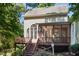 Exterior backyard view of home featuring a sunroom and wooden deck with stairs at 5940 Dahlberg Dr, Raleigh, NC 27603