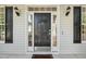 Charming front door with sidelights, transom window, brass hardware, and covered front porch at 5940 Dahlberg Dr, Raleigh, NC 27603
