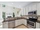 Well-lit kitchen features granite countertops, stainless steel appliances, and tile backsplash at 5940 Dahlberg Dr, Raleigh, NC 27603