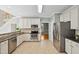 Bright kitchen with white cabinets, stainless steel appliances, and neutral tile flooring at 5940 Dahlberg Dr, Raleigh, NC 27603