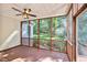 Screened-in porch with wood flooring, ceiling fan, and view of wooded backyard at 5940 Dahlberg Dr, Raleigh, NC 27603