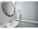 Elegant powder room with decorative mirror and pedestal sink at 5940 Dahlberg Dr, Raleigh, NC 27603