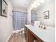 Bathroom featuring sink, toilet, blue patterned shower curtain and a wood cabinet at 614 Marian Way, Sanford, NC 27330