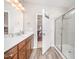 Bright bathroom with dual sink vanity, shower, and wood flooring at 614 Marian Way, Sanford, NC 27330